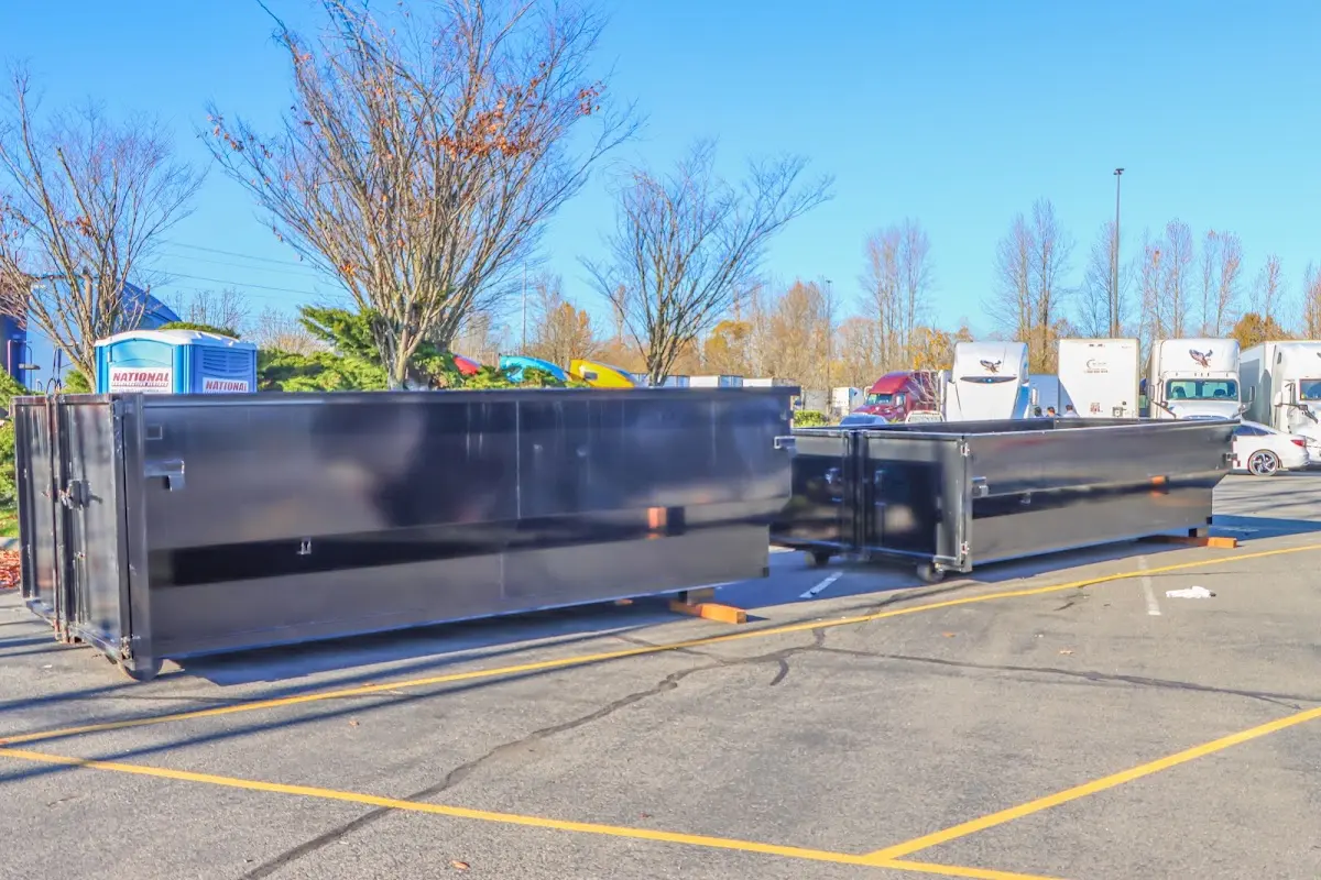 Professional dumpster rental service with roll-off container on residential driveway in St. Francis